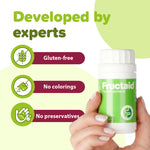 Hand holding a Fructaid supplement bottle with green and white design on a light green background. 