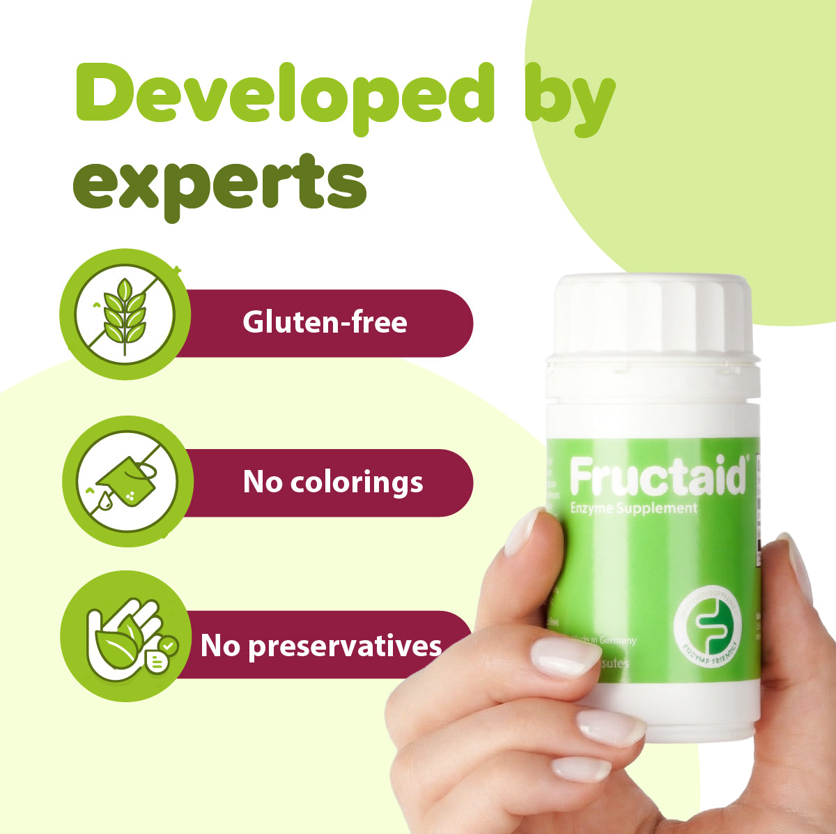 Hand holding a Fructaid supplement bottle with green and white design on a light green background. 